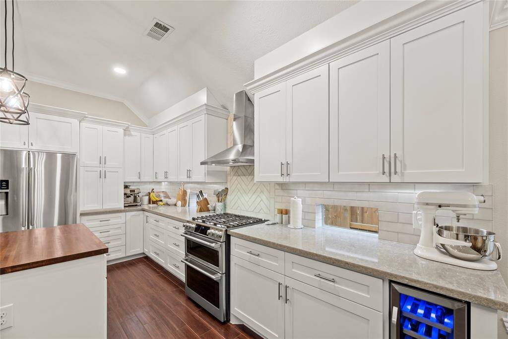 Crisp white cabinets with updated hardware provide a clean and timeless look, enhancing the sense of brightness and openness in this space.