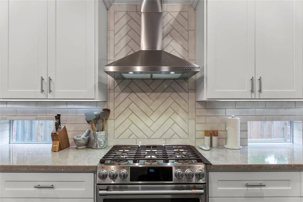 Quartz countertops paired with a coordinating stone backsplash not only provide a durable and elegant surface for food preparation but also add a touch of luxury and sophistication to the kitchen, enhancing the large 5 burner stove.