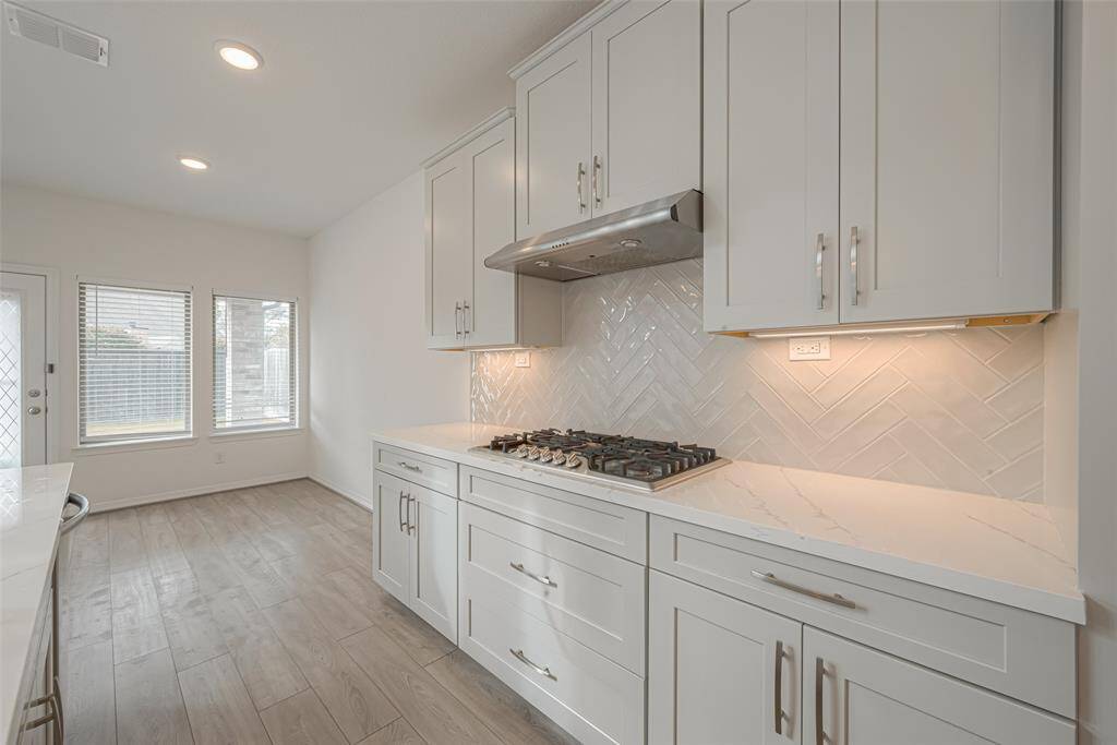 With ample cabinets, stylish tile backsplash, and under cabinet lighting.