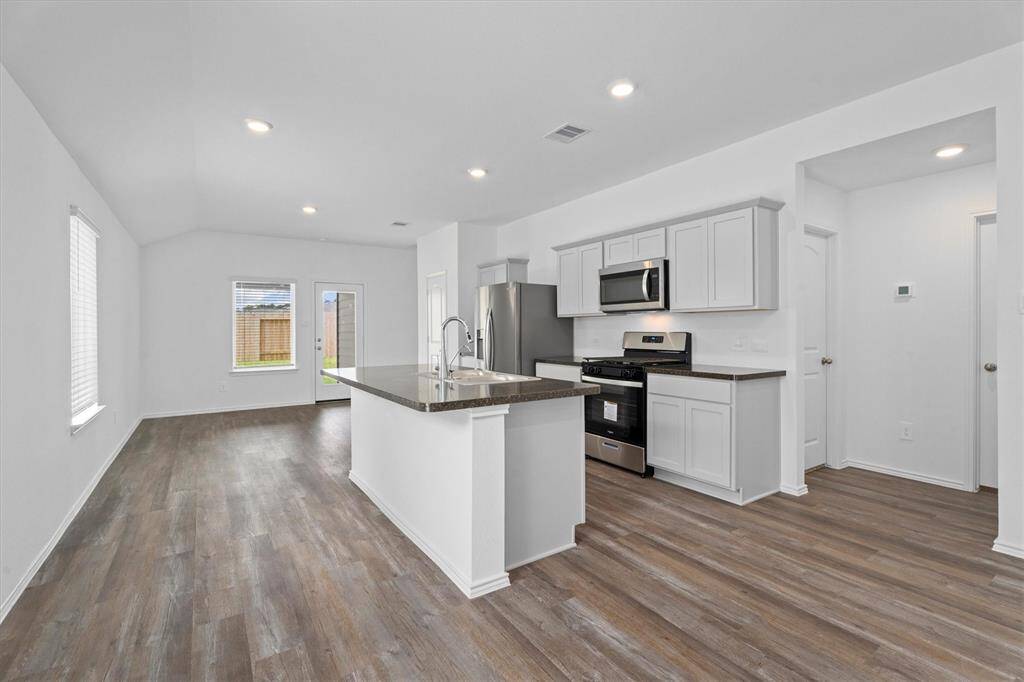 Sleek, modern kitchen showcases granite countertops, soft-close shaker cabinetry, stainless steel Whirlpool appliances.