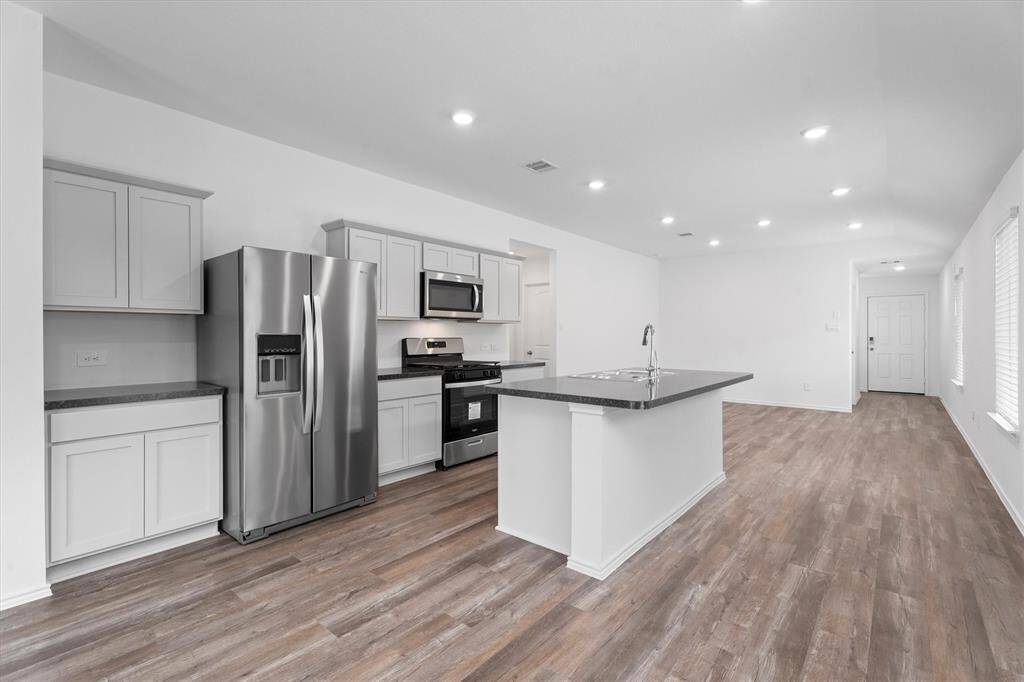 center island with dual-basin sink and gooseneck faucet. Recessed lighting adds a contemporary touch.