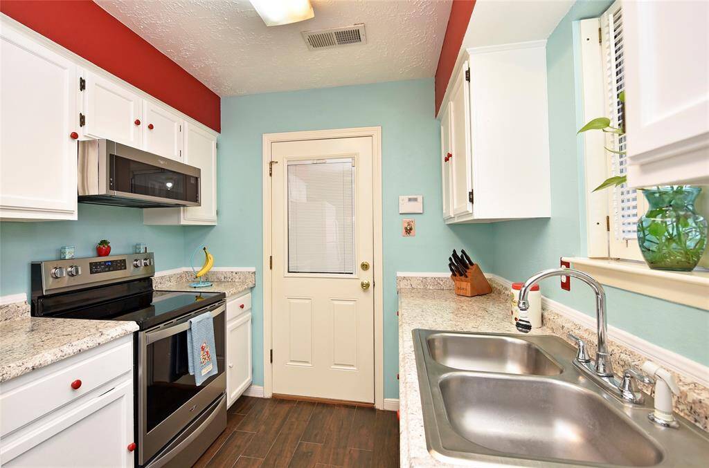 The kitchen has a flat surface range with vent hood/microwave.