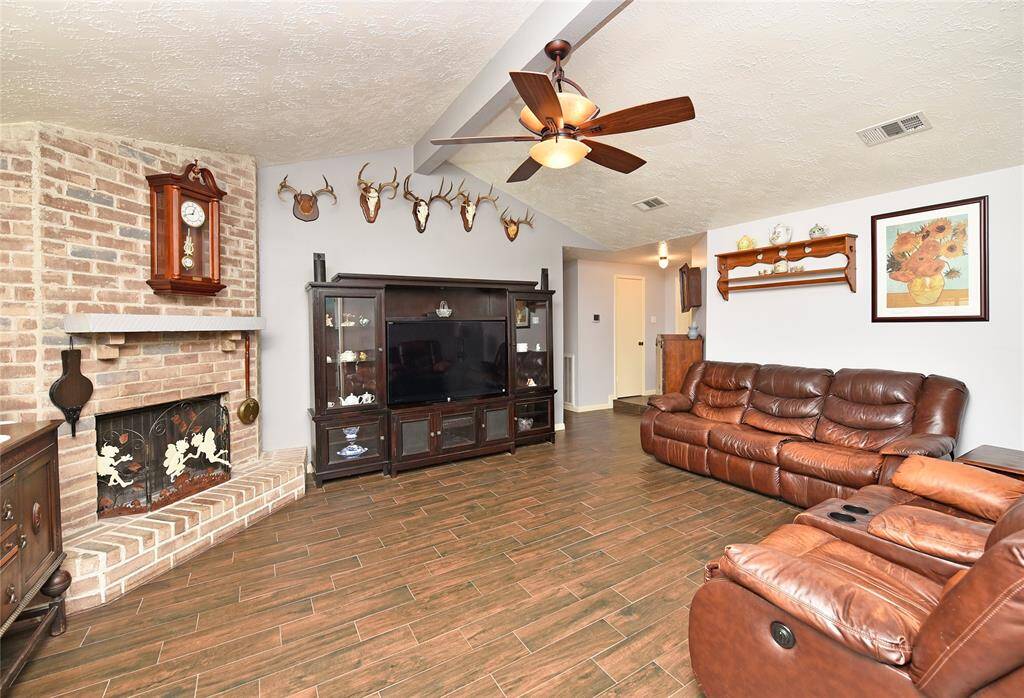The family room offers the same wood-look tile, vaulted ceilings and a wood burning fireplace.