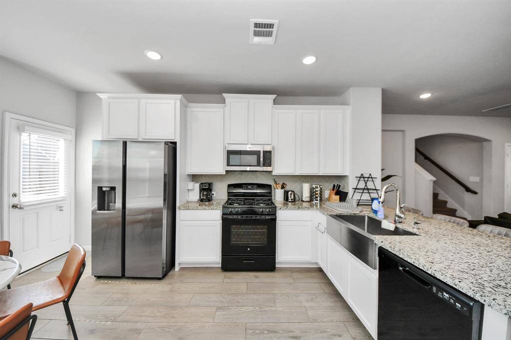 White kitchen with large farmhouse style sink.
