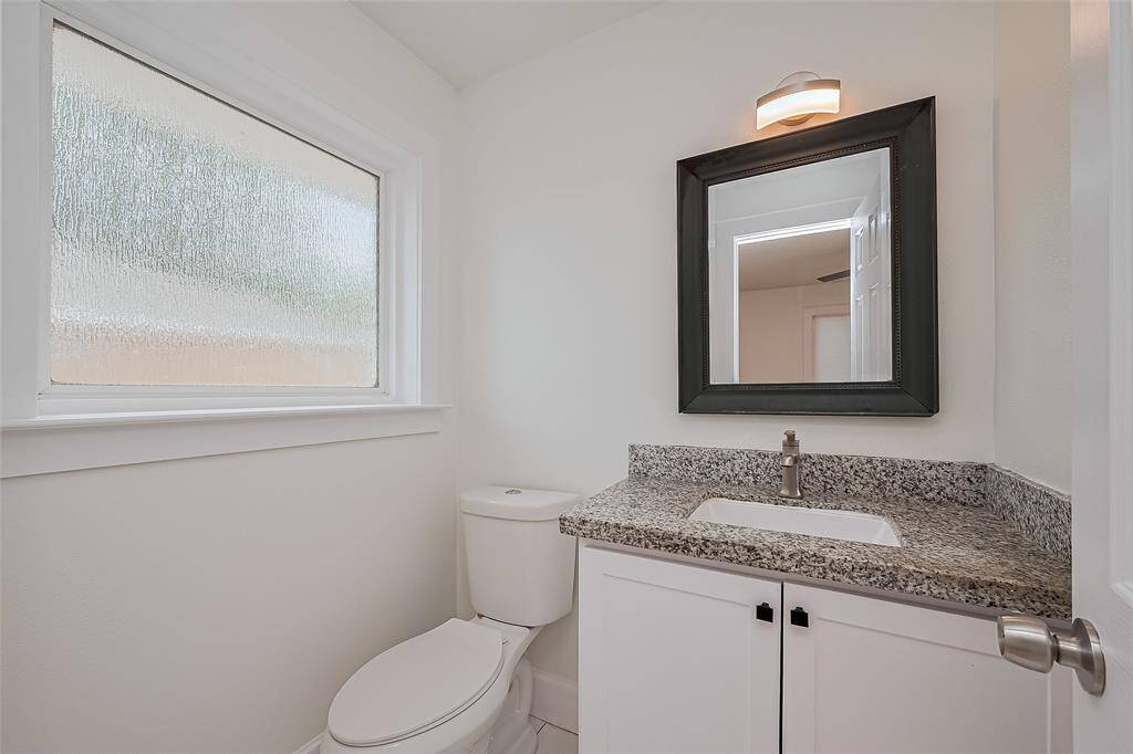 Half bath features granite counter and tile flooring
