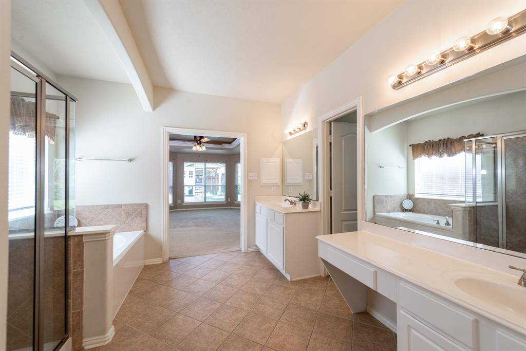 Discover the spacious primary bath featuring dual vanities, a separate shower and tub, and a generous walk-in closet.