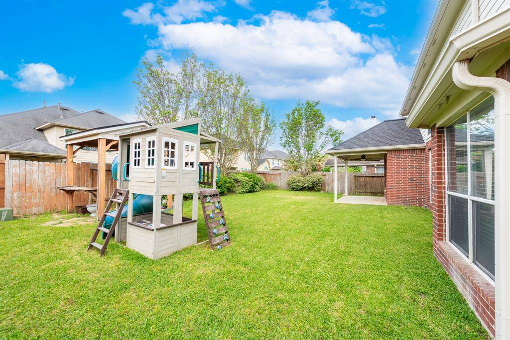 Spacious backyard ideal for a playset and lush garden.