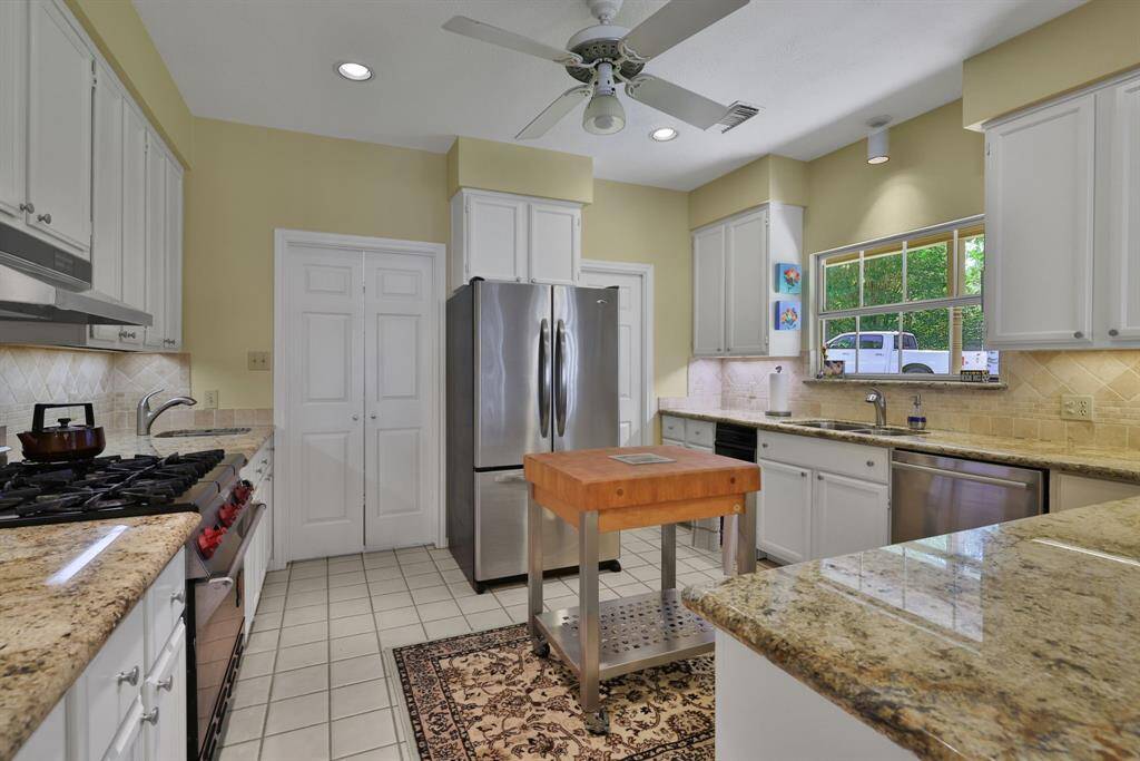 The kitchen features granite counter tops, commercial gas range and stainless steel appliances