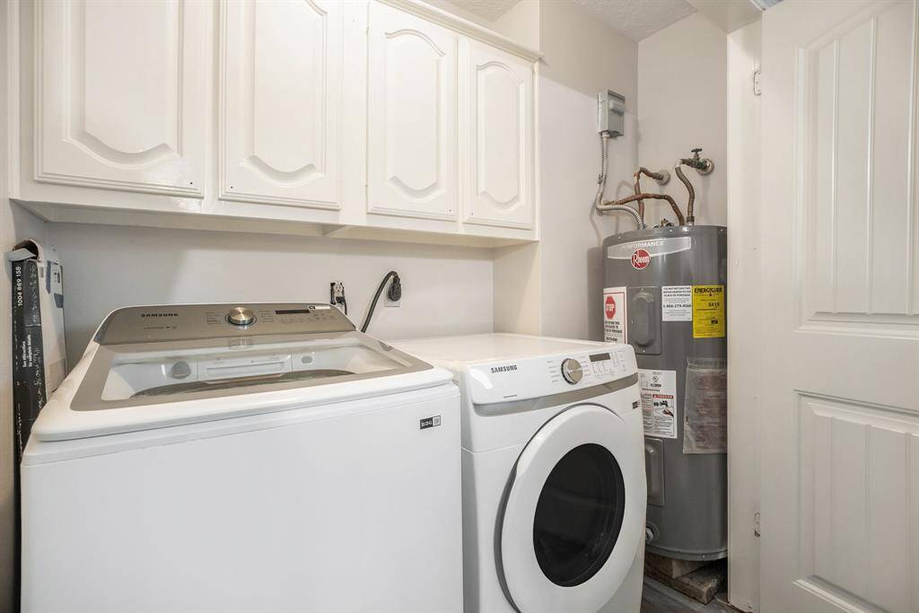 Laundry Room located within the home featuring delicate white cabinetry for storage and fabulous flooring.