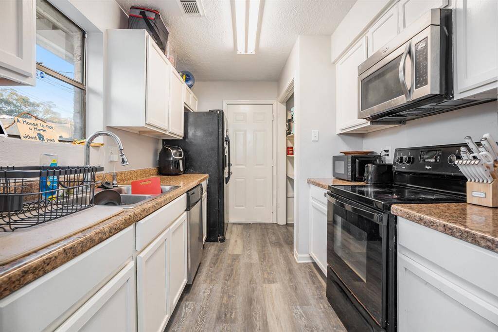 Gourmet Kitchen boasts granite countertops, delicate white cabinetry, natural lighting from window and tons of space for preparing meals.