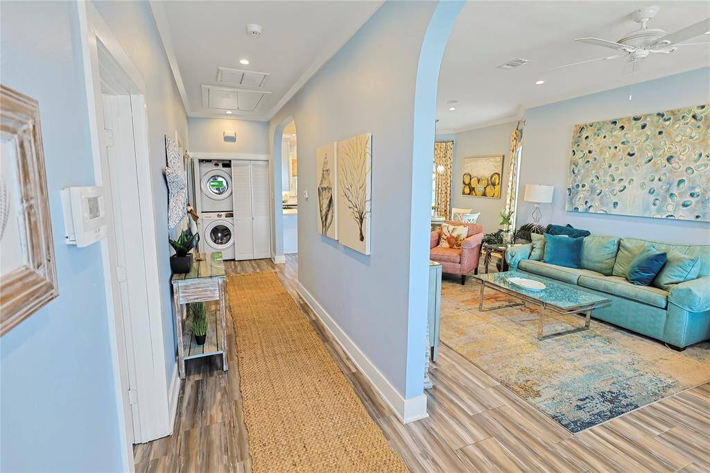 This inviting home features a ton of natural light, beautiful flooring leading to the cozy living area and includes a stackable washer and dryer in this modern, open-plan design.