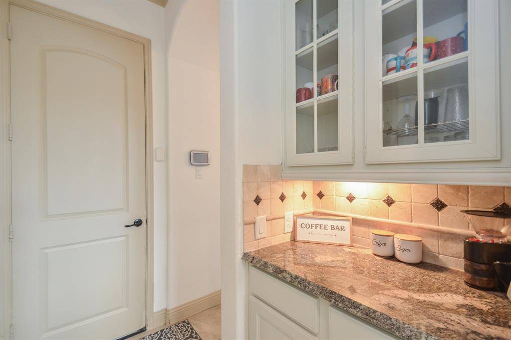The often unsung hero of a lush kitchen is this, the butler's pantry, with convenient counter space and glass-front cabinetry, above.