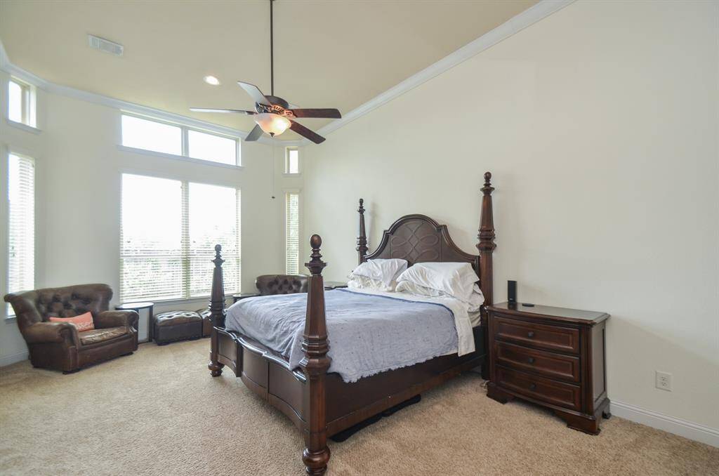 This is the exact depiction of what a plush place of peace and repose should be! Your primary suite is embraced by a gorgeous high ceiling, walls of windows, and lots of carpeted floor space for every favorite bedroom treasure!