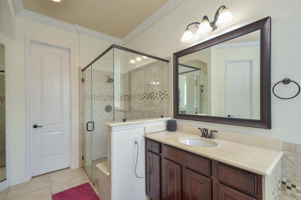 Your bright primary ensuite bath features dual/separate sinks; and in this view, a look at the huge walk-in, glass enclosed shower.
