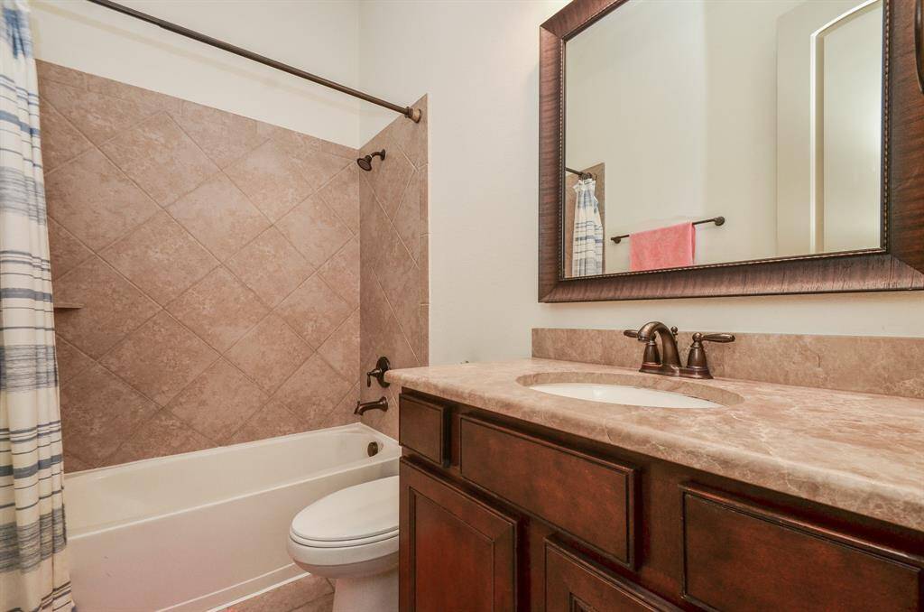 A beautiful combined bathtub/shower offers easy options in this warm secondary bathroom.