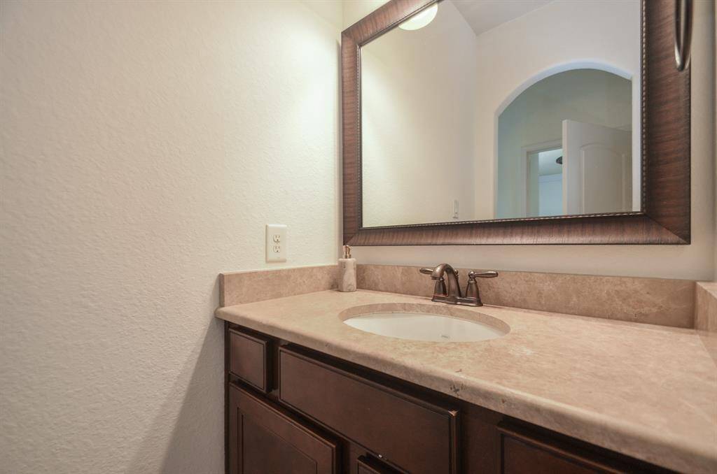 The light/dark color theme warms this secondary bathroom.