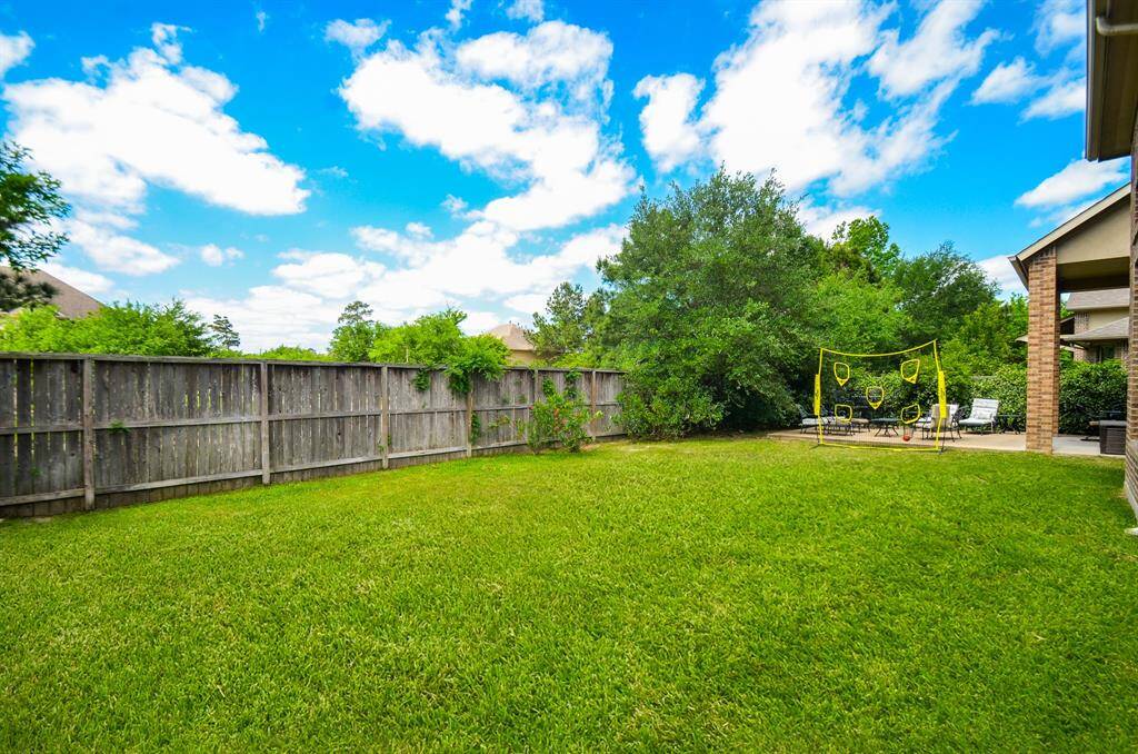 Vibrant green grass and sturdy privacy fencing fills the back property.