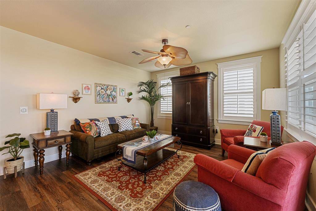 This beautifully furnished space blends comfort and style, with plush seating, vibrant accents, and timeless details like wide plank flooring and crown molding.