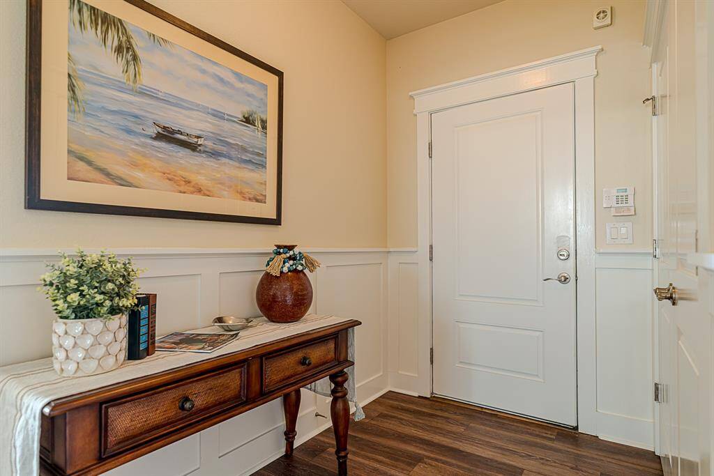 This charming entry sets the tone with coastal-inspired artwork and a functional layout, including easy access to a full-size laundry closet discreetly tucked away behind double doors.