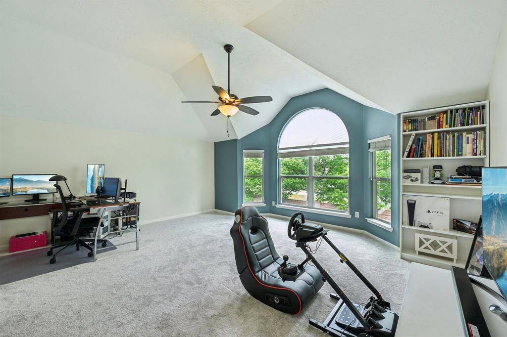 Game room with bay windows overlooking backyard