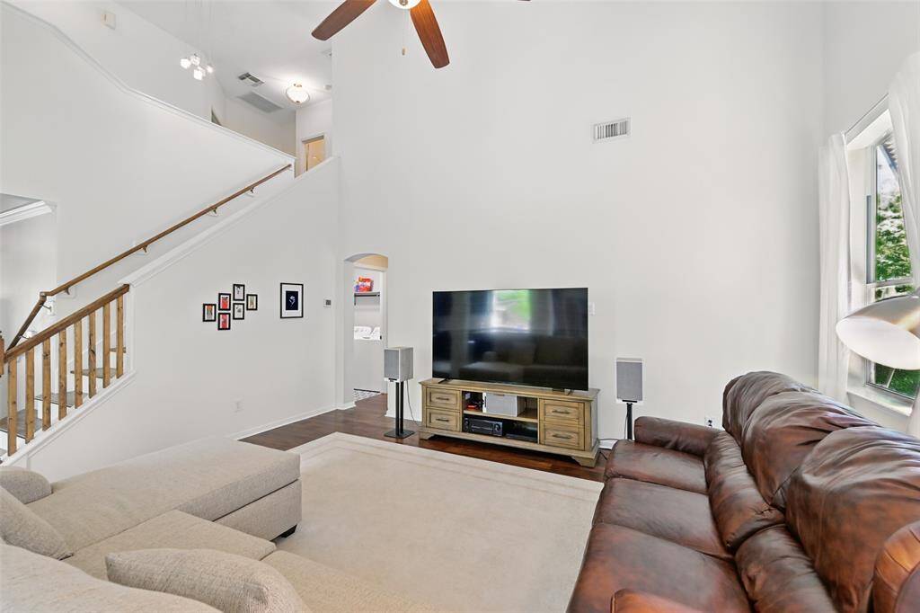 The family room features a staircase leading to the upstairs bedrooms, complete with elegant wooden railings..