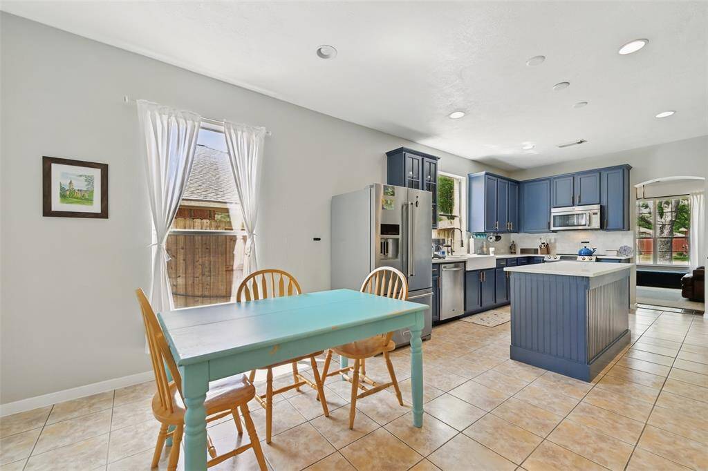 The breakfast room and kitchen feature elegant ceramic tile flooring and modern recessed lighting.