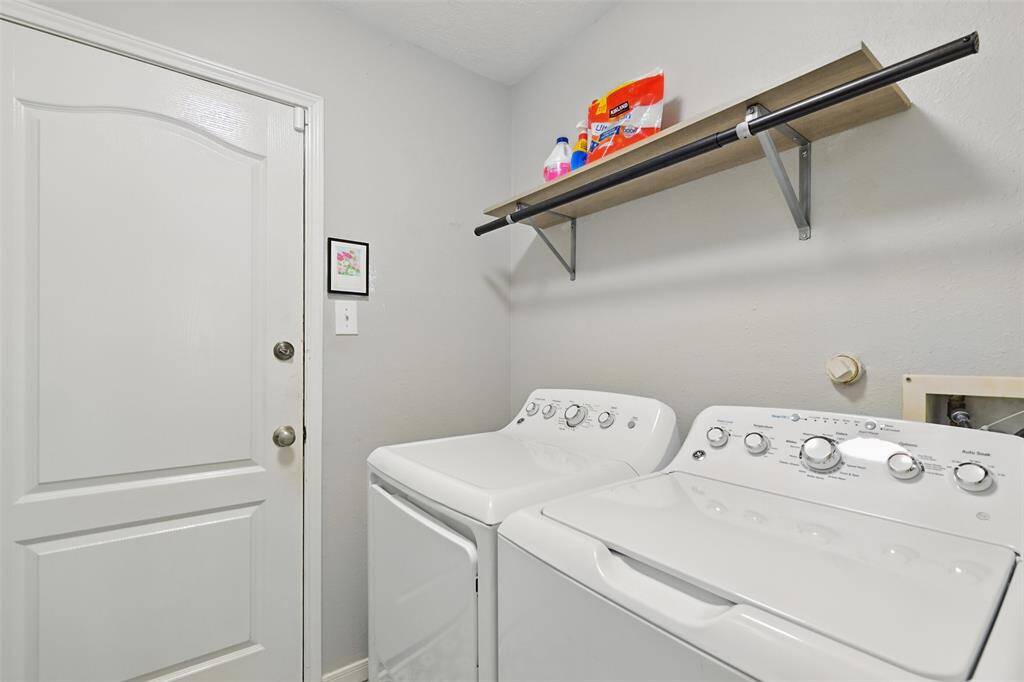 Utility room featuring shelving and a wooden dowel.