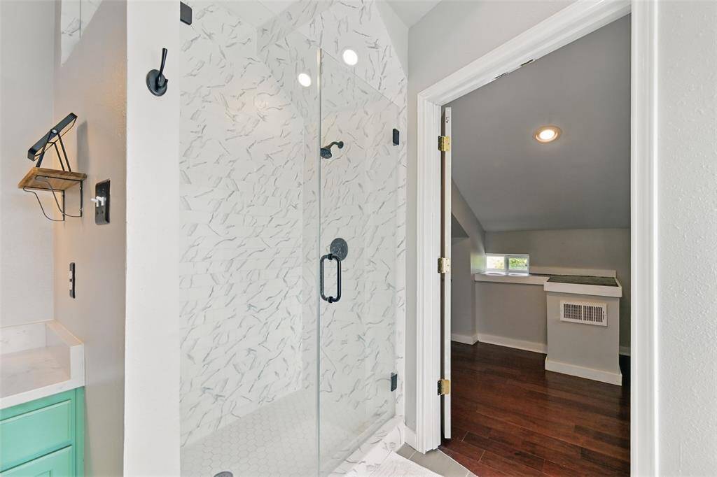 A walk-in shower featuring a sleek glass door, with direct access to the versatile flex room.