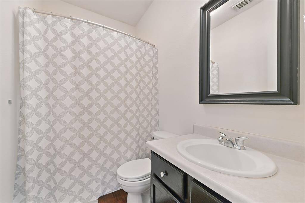 The upstairs bathroom features a sleek cultured marble sink and vanity, an elongated toilet, and a combined tub and shower for added convenience.