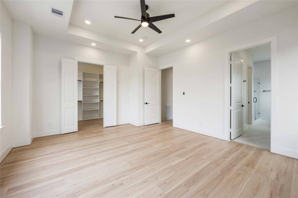 Head to the 3rd floor where you'll find an amazing primary suite under an elegant tray ceiling. Notice a large walk-in closet on the left and a peek into the en-suite bath.