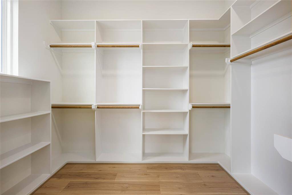 This walk-in closet belongs to the primary bedroom. So much storage on every side!