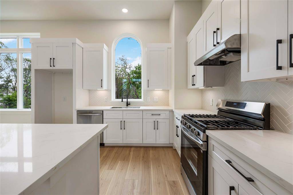 Gorgeous quartz counters, a sleek herringbone backsplash, and under-cabinet lighting add to the style and charm.