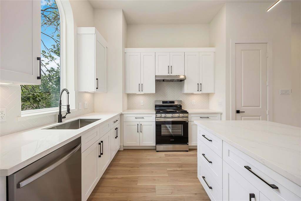 A stylish arched window rests above the sink adding another dimension to the beauty of this space.