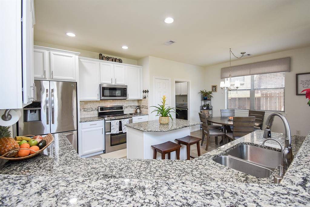 This is nothing short of any cook's or host's dream kitchen, with ample walking space, good looking granite? quartz? counter tops and tons of cabinetry available wherever your prepping, cooking and serving tasks, take you. Note room for additional stools under the extended island counter. Great natural light surrounds the probable breakfast/casual dining nook, up right; with the entrance to the utility room, to its left.