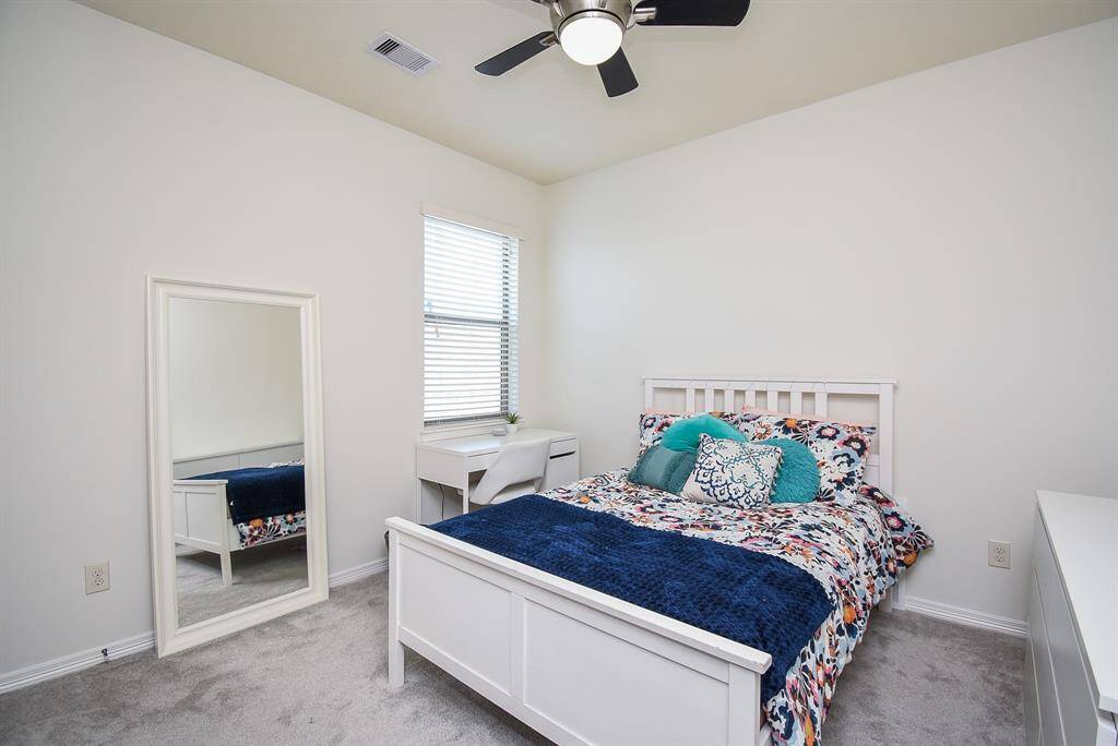A spacious carpeted secondary bedroom features a corner window, which gives you more wall space for furnishings.
