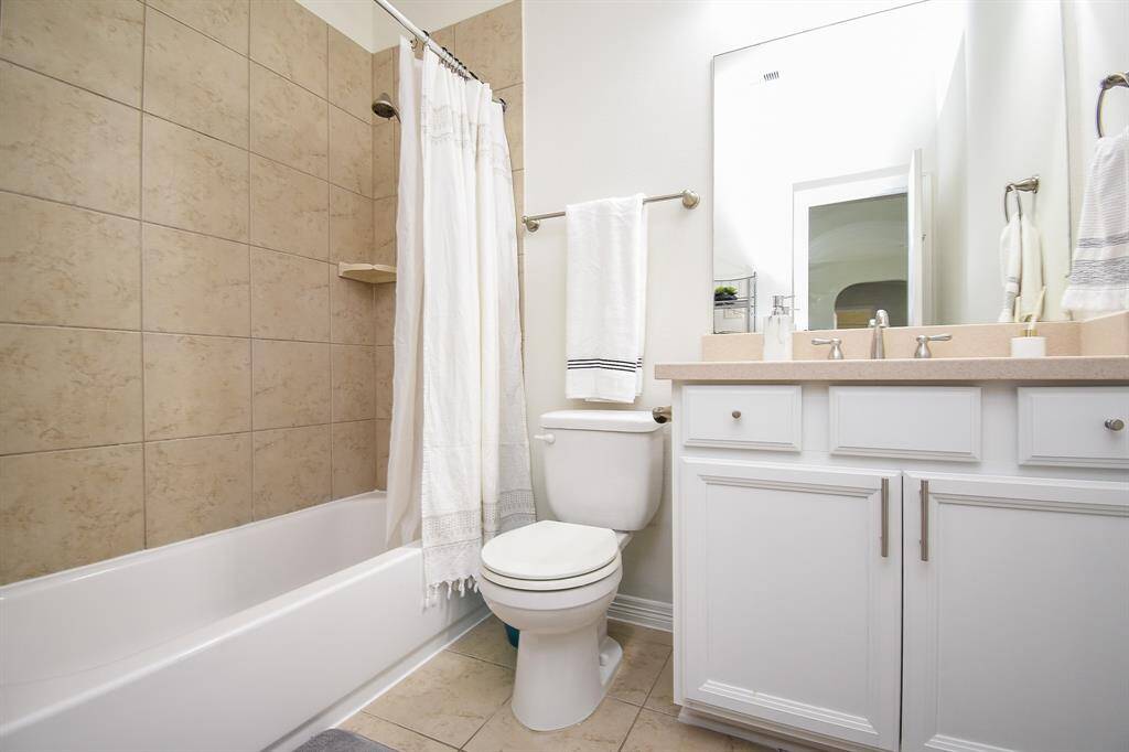 A tranquil secondary bath features combined shower/bathtub for personal preferences.