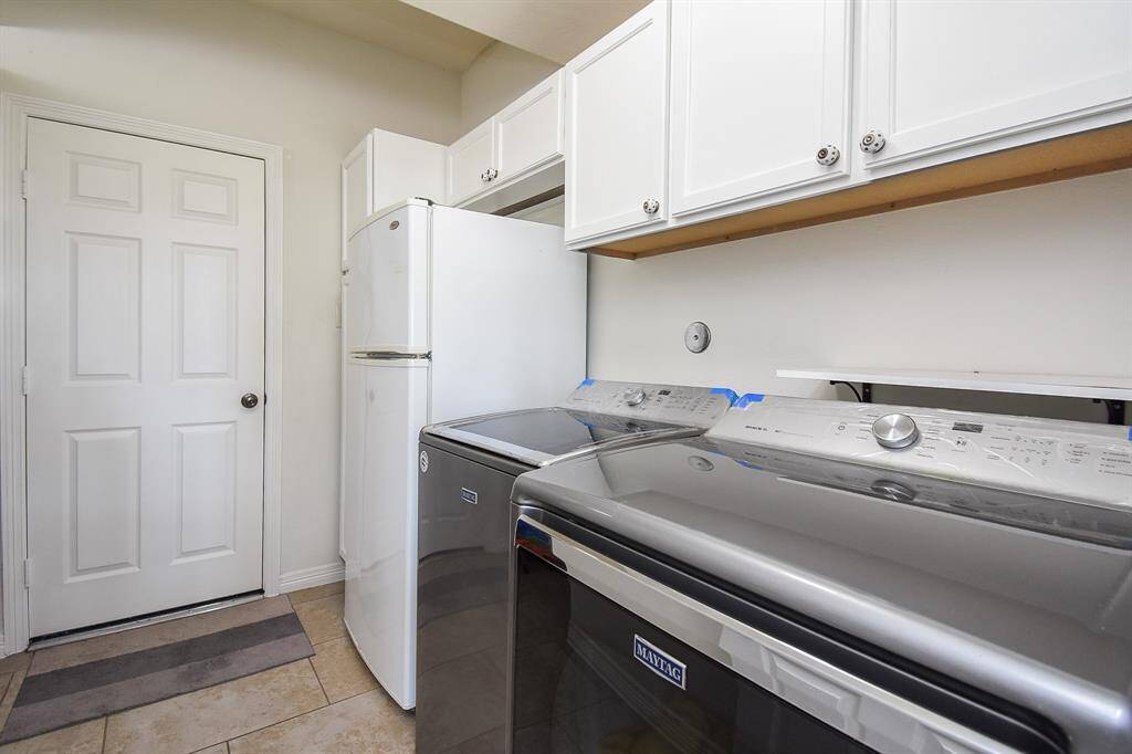 A large utility room is located just off the kitchen breakfast nook, with room galore for laundry appliances, an additional fridge as suggested, and lots of handy storage, above.