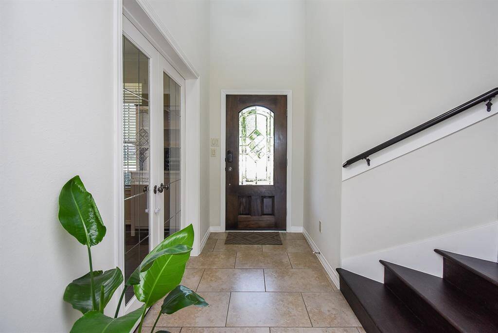 The front entrance from the inside is a peaceful blend of light/dark tones, with tile flooring. To the left, behind clear-paned french doors, is the perfect home office/study, or anything you need/want it to be.