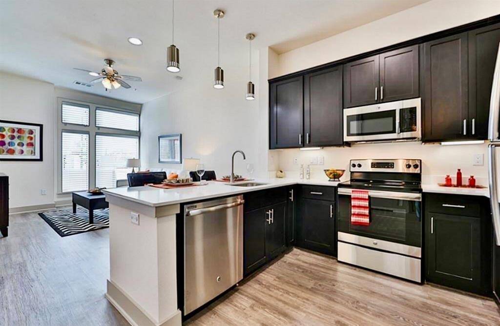 Stainless kitchen appliances and a dining/work island. Note the large windows! The huge walk in closet (not shown) in this photo is behind the refrigerator (you can see the door handles on the right).