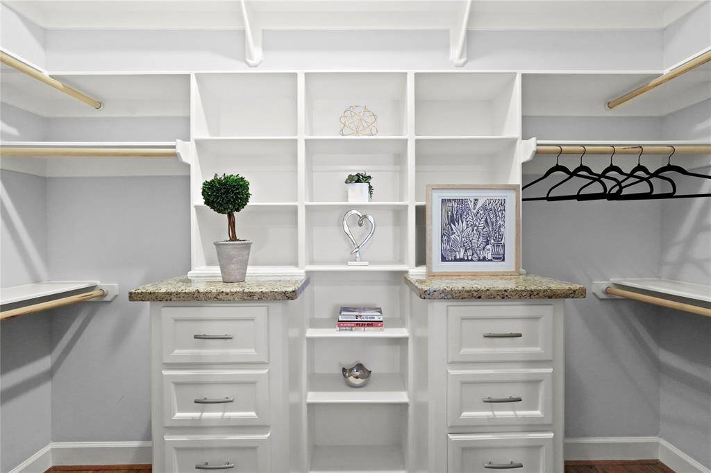 Well-organized walk-in closet with custom shelving, drawers, and hanging space, featuring a neutral color palette and elegant design details.