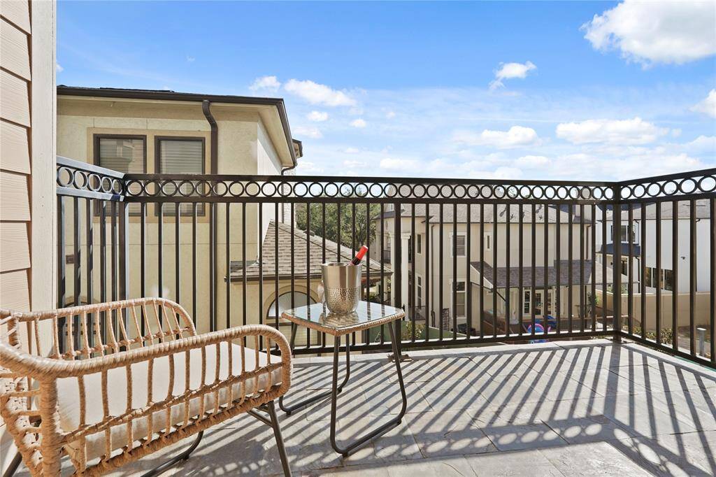 Cozy balcony with decorative iron railing, offers a comfortable outdoor space perfect for enjoying your beverage of choice and the view of the neighborhood.