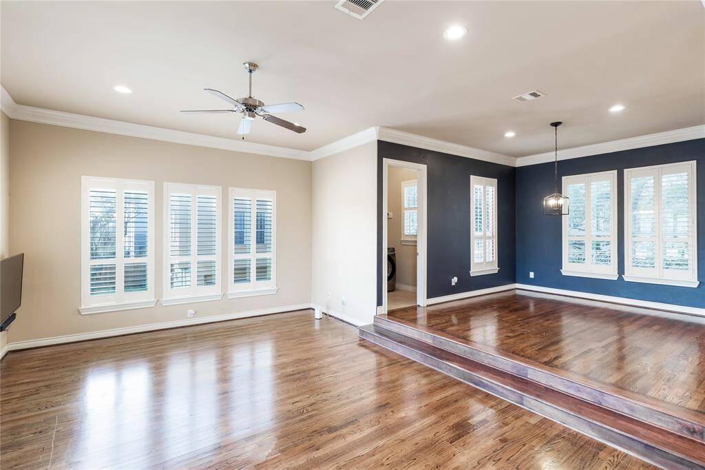 second floor view of the sunken living room and dining room area flooded with natural light from windows all around.