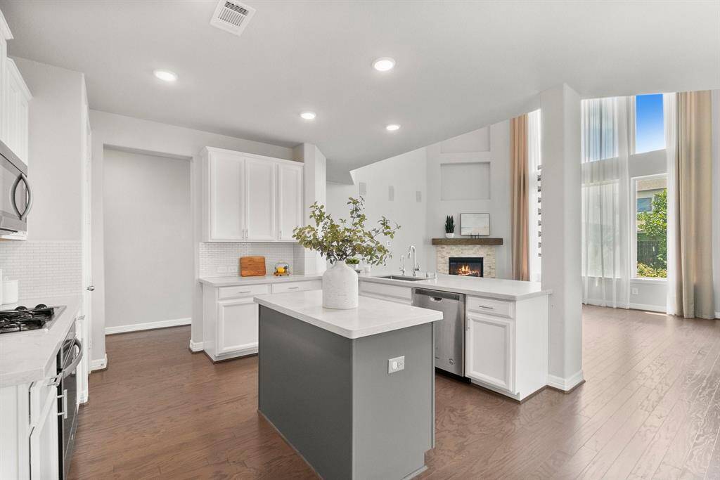 A contrasting center island adds character to the crisp, white kitchen