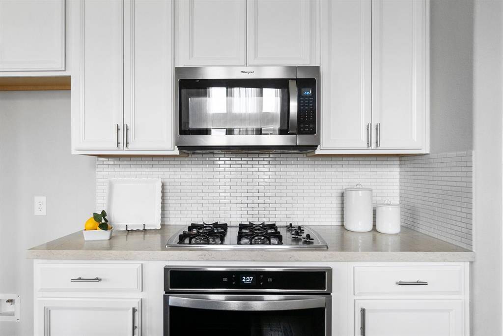 The modern tile backsplash and countertops create a beautiful, neutral backdrop