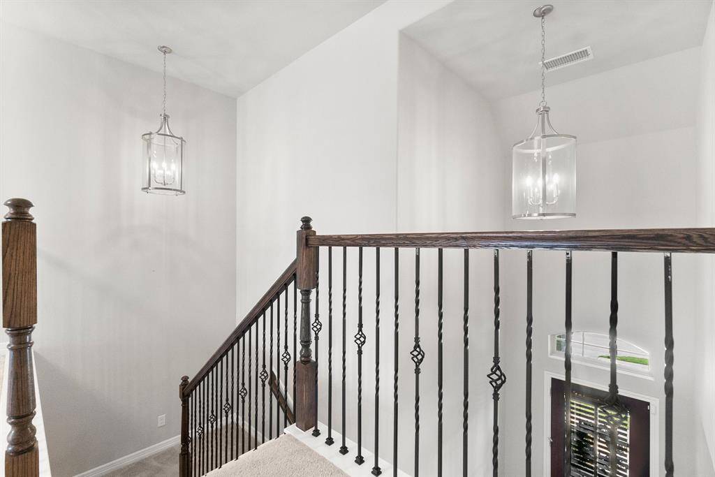Lovely wrought iron and wood stairs lead to the upstairs bedrooms and separate game room
