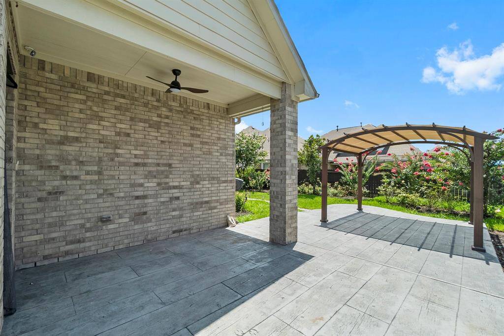The covered patio features a ceiling fan