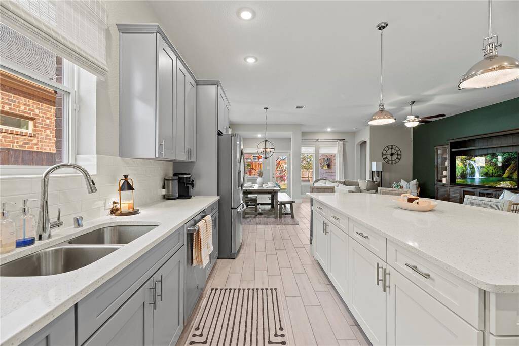 Richly painted cabinets with updated hardware provide a clean and timeless look, enhancing the sense of brightness and openness in the space.