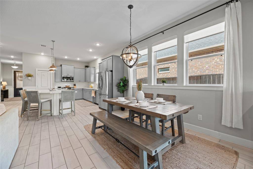 The dining area is ideal for a full-sized table and features easy care tile  floors, designer paint, large bright windows, and overhead chandelier.