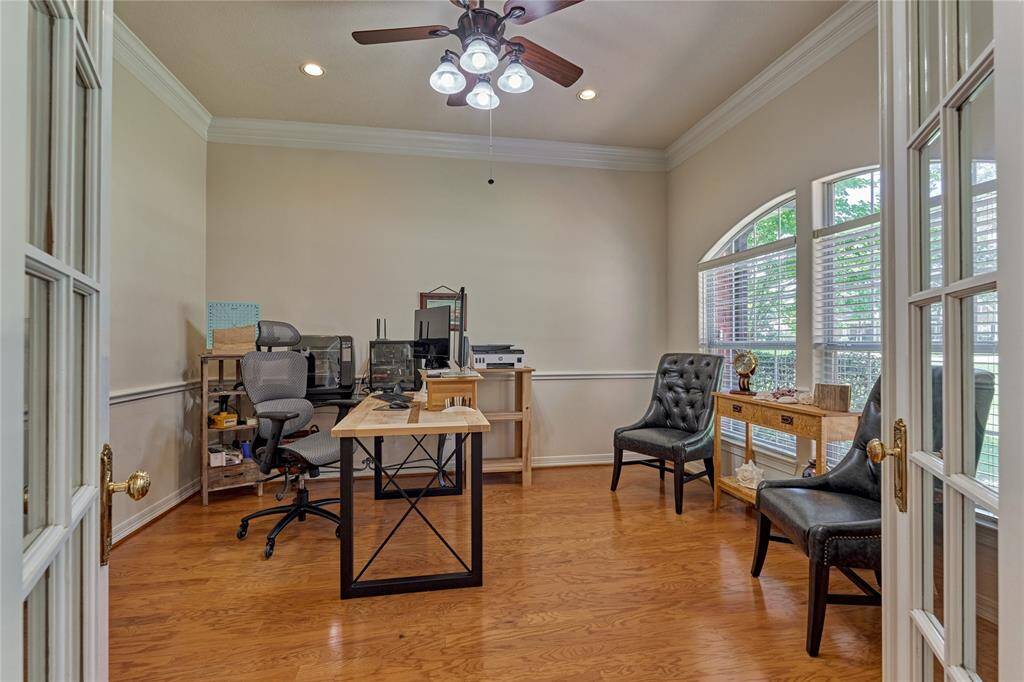 The office features crown molding and overlooks the expansive front yard.