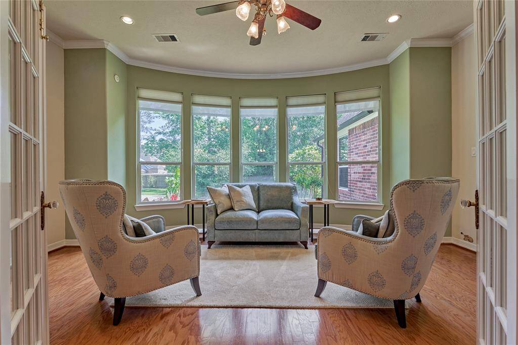 It feels like you are seated outdoors in the bonus/flex room, which features French doors and a wall of windows.